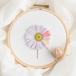 An artistic image of a delicate embroidery hoop displaying a beautifully crafted daisy flower in soft pastel colors, featuring light pink, lavender, and pale yellow tones, stitched with fine thread