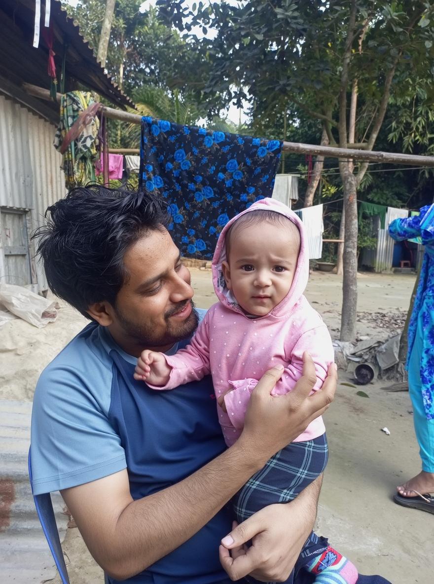 A heartwarming scene of a man holding a small child in a cozy park setting