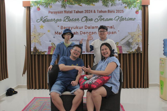 A festive family gathering with four cheerful individuals, celebrating together