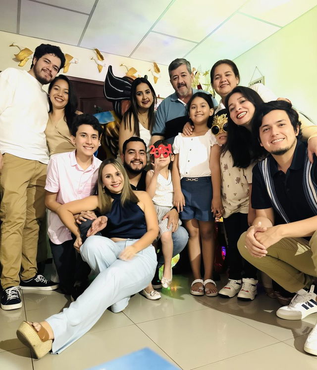 A large family gathering in a cozy living room, with people smiling and interacting joyfully