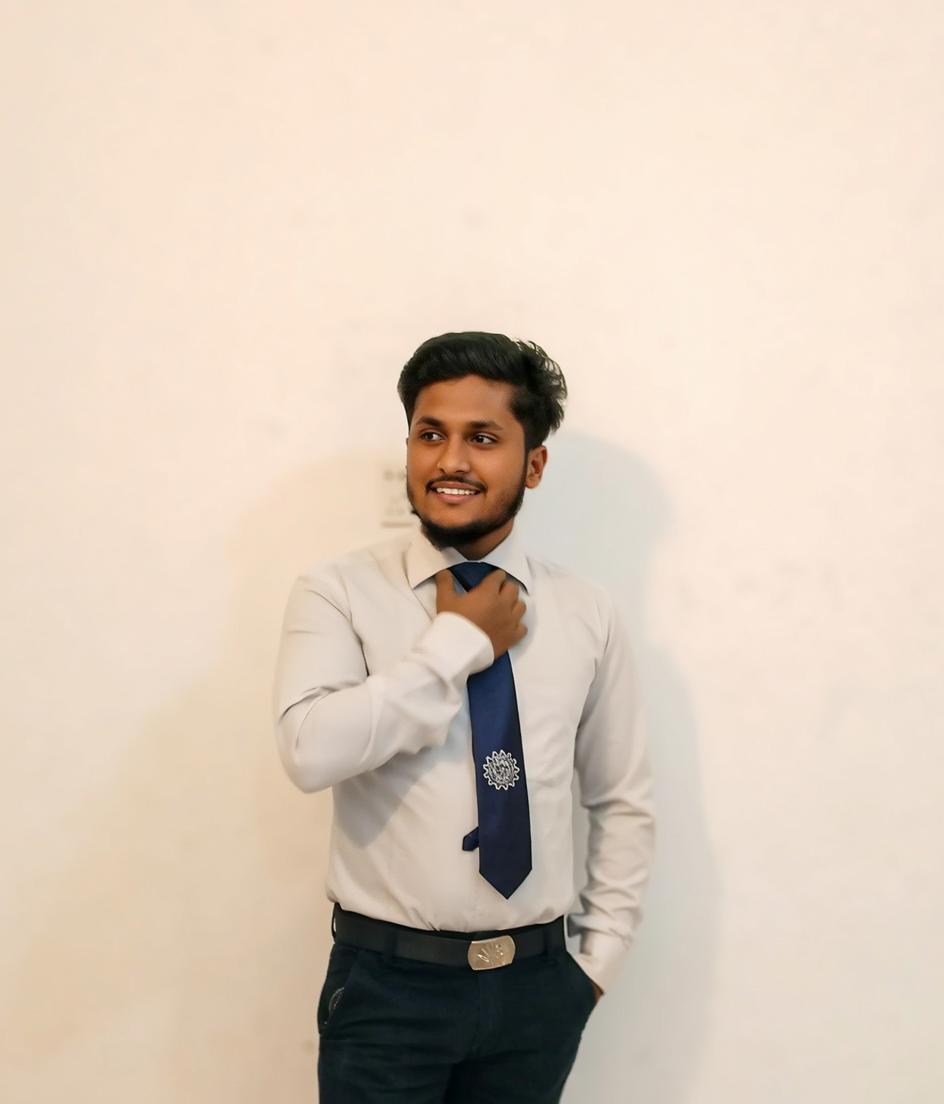 A young man standing confidently, adjusting his tie with a smile