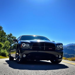 A sleek, aggressive black 2006 Dodge Charger parked on a scenic road