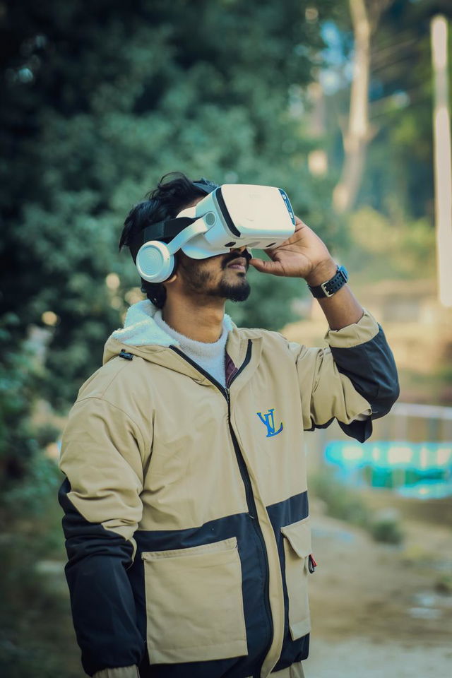 A young man wearing a stylish virtual reality headset, gazing thoughtfully into the distance