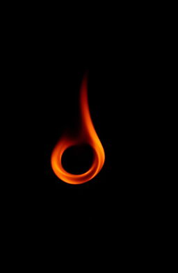 A small, captivating red flame swirling gracefully in a spiral against a completely black background