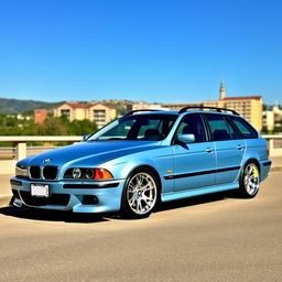 A BMW E39 Touring from 2002 with a bluish color, without M package, featuring a subtle lowering and 17-inch M Power wheels