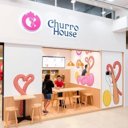 A small modern churros shop designed with a vinotinto, white, and light beige color scheme