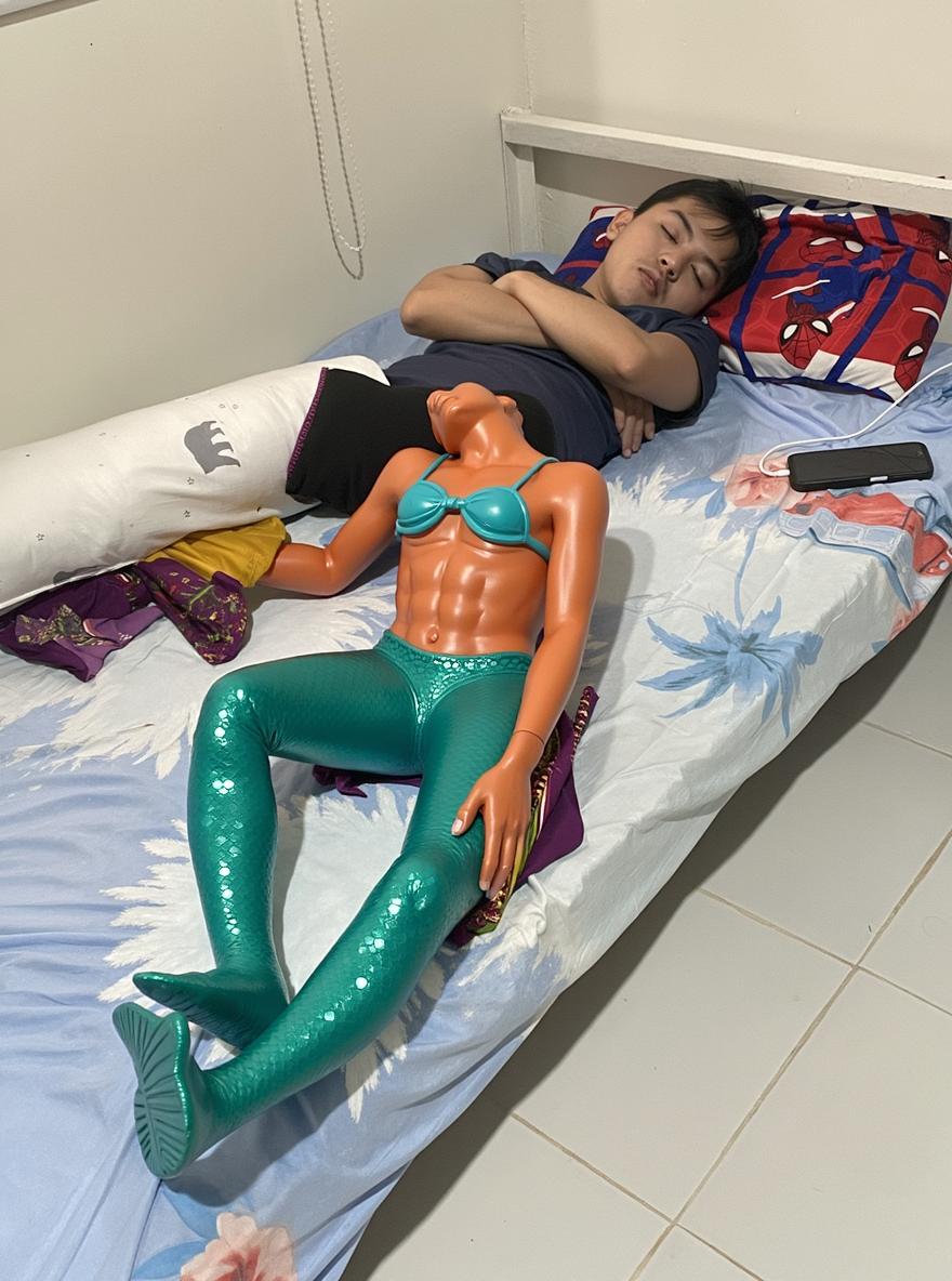 A whimsical scene depicting a young person sleeping peacefully in a colorful bed, inspired by the idea of mermaid legs