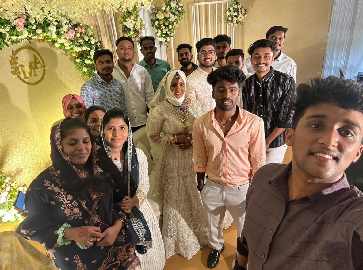 A joyful group portrait featuring a large gathering of family and friends at a festive event, with everyone smiling