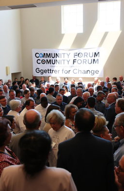 A diverse group of people gathered in a town hall meeting, discussing important community issues