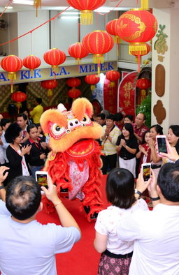 A vibrant celebration of Imlek, featuring a lion dance (Barongsai) performance in a festive setting