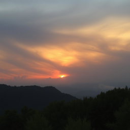 A breathtaking landscape featuring a dramatic sunset behind a mountain range, with a foreground of lush, vibrant green trees