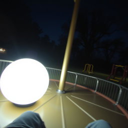 A night scene as seen from the perspective of someone sitting on a metal merry-go-round, capturing the feeling of spinning around