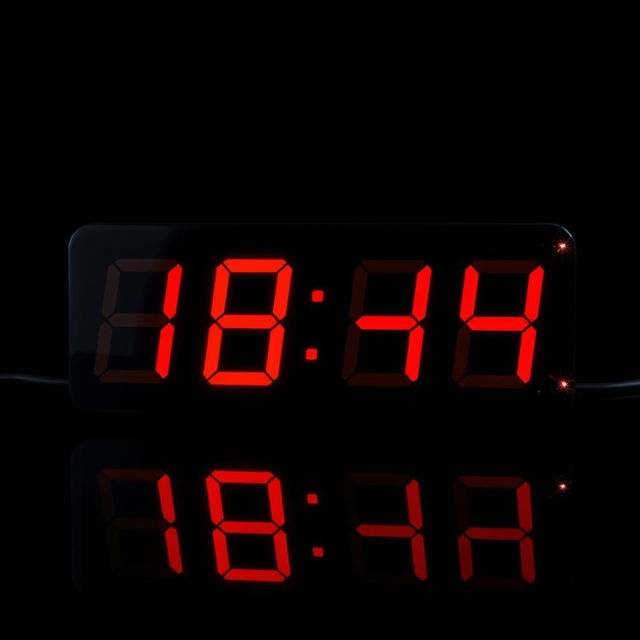 A digital clock showing the time exactly one hour ago, with bold red numbers indicating the time