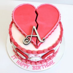 A beautifully designed birthday cake featuring a large broken heart motif on top