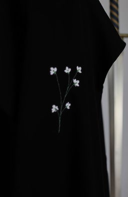 A close-up view of a small section of a black cloak, showcasing two or three rough folds