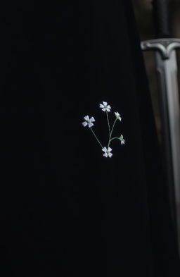 A close-up view of a small section of a black cloak, showcasing two or three rough folds