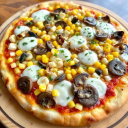A delectable pizza topped with sweet corn kernels, crunchy dices of onions, and tender, sautéed mushrooms, all generously layered with gooey mozzarella cheese that is perfectly melted and bubbly