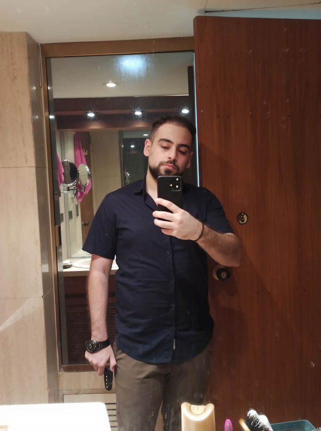 A sleek and modern black iPhone 14 Pro Max on a polished wooden table