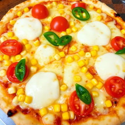 A mouthwatering pizza featuring sweet corn and juicy tomatoes, complemented by fresh green capsicum