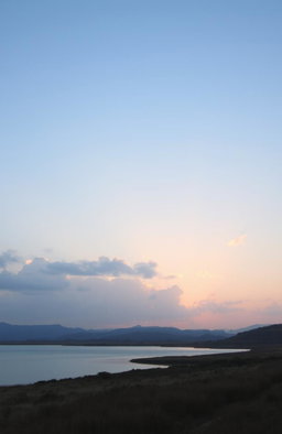 A serene landscape at dawn or dusk, featuring a soft sky in light blue or pink hues, reflecting the sweetness and tranquility of love