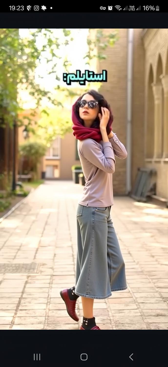 A stylish, confident woman walking casually down a sunlit path lined with trees