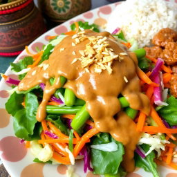 A colorful platter of Pecel Salad, featuring a vibrant assortment of vegetables such as steamed spinach, grated carrots, green bean, and cabbage all beautifully arranged