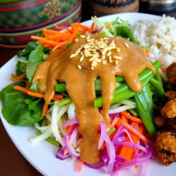 A colorful platter of Pecel Salad, featuring a vibrant assortment of vegetables such as steamed spinach, grated carrots, green bean, and cabbage all beautifully arranged