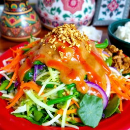 A colorful platter of Pecel Salad, featuring a vibrant assortment of vegetables such as steamed spinach, grated carrots, green bean, and cabbage all beautifully arranged