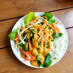 A beautifully arranged plate of Pecel Salad, showcasing a vibrant assortment of steamed vegetables including spinach, bean sprouts, and sliced carrots, all drizzled with a rich and creamy peanut sauce