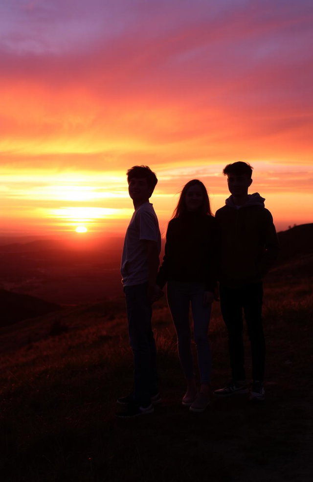 A picturesque scene of a teenager standing on a hilltop at sunset, holding hands with a female friend, while another friend stands beside them
