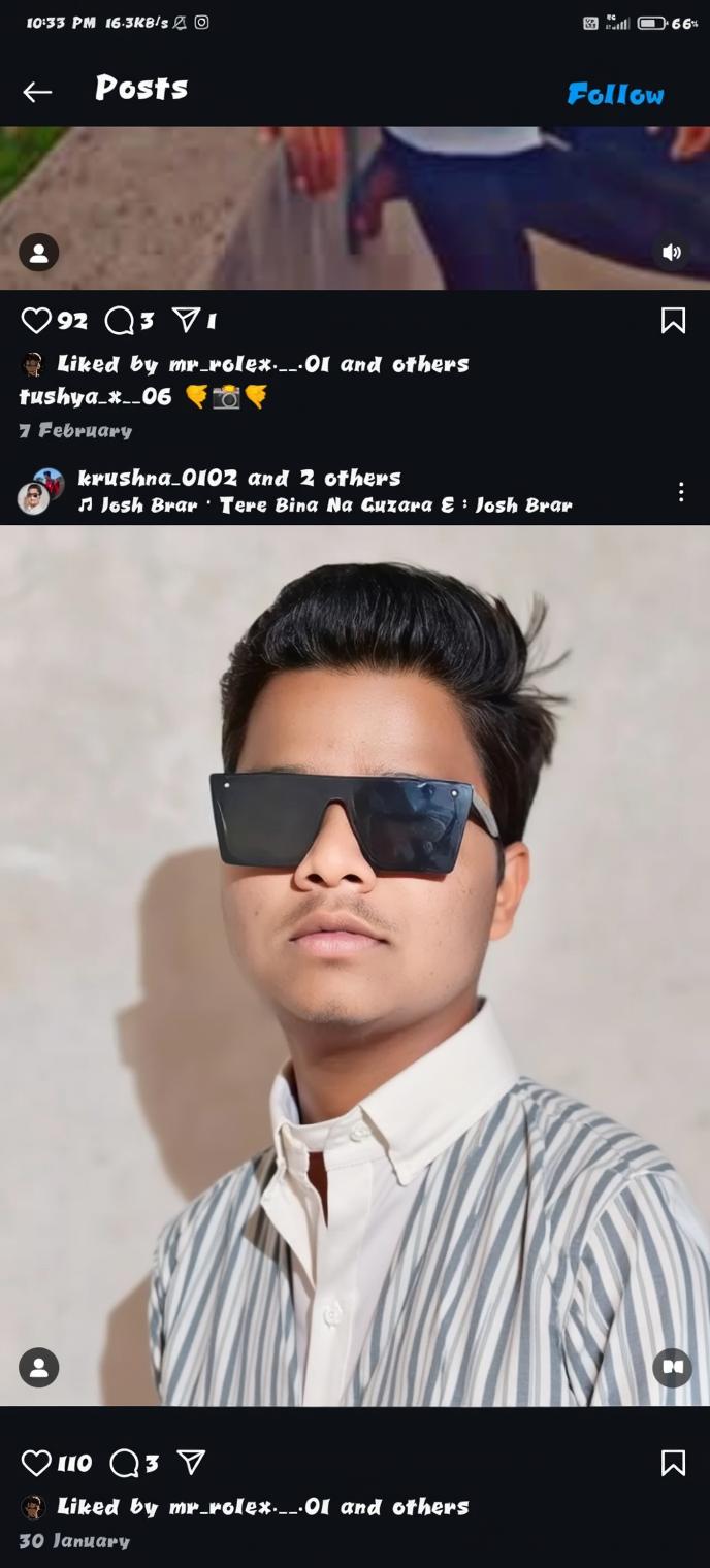 A young man with a confident expression, wearing fashionable oversized sunglasses and a crisp white shirt