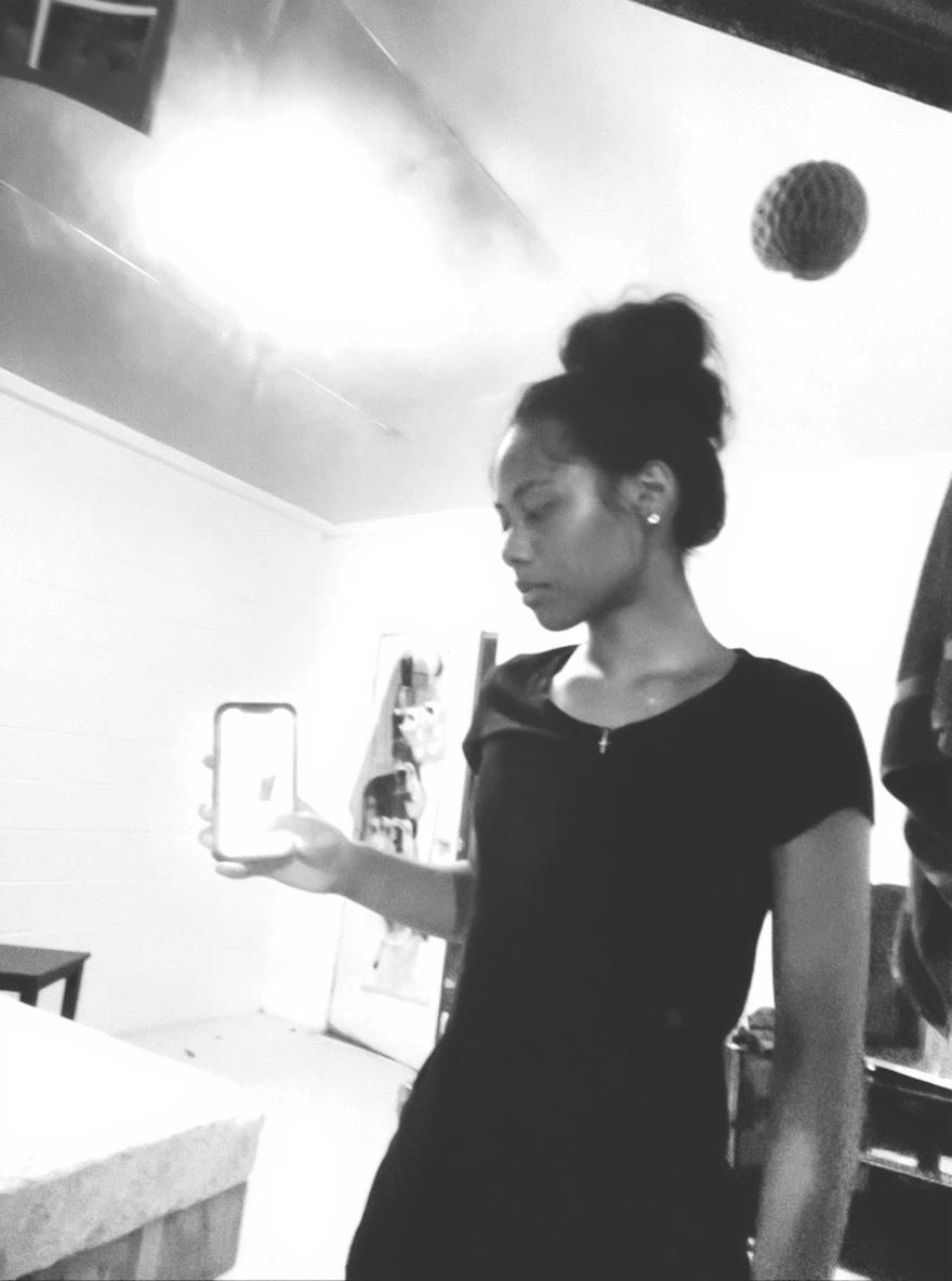A stylish portrait of a young woman standing in a softly lit room