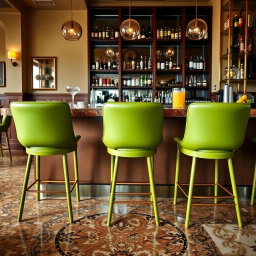 A stylish restaurant bar featuring six bar stools in vibrant avocado green color