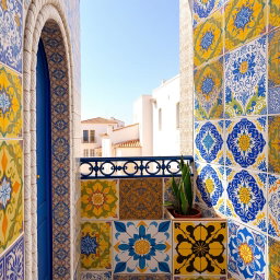 An artistic display of Portuguese styled tiles featuring intricate patterns, primarily in vibrant shades of yellow, blue, and soft pink