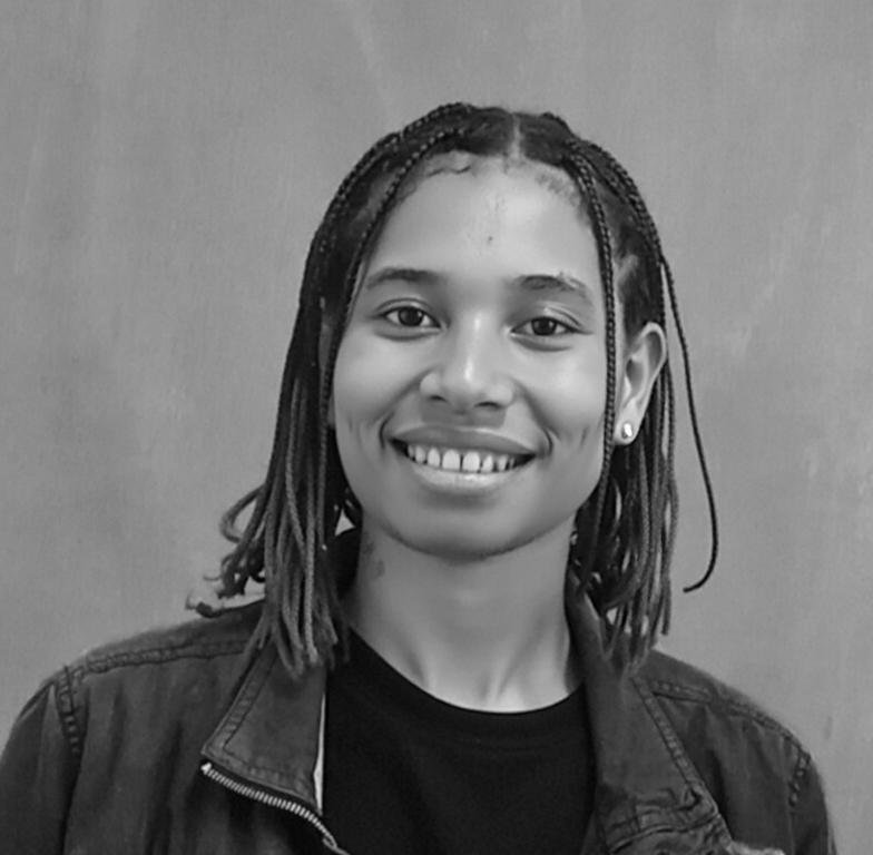 A portrait of a person smiling confidently with a microphone in front of them
