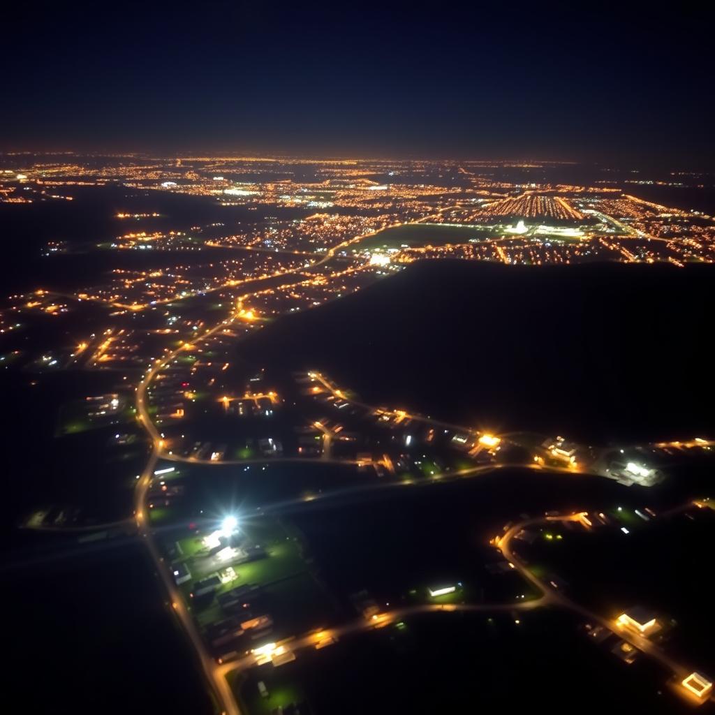 An aerial or satellite image taken at night of a distant view of a city, showcasing a contrast of brightly lit houses that shine and sparkle among areas that are much darker