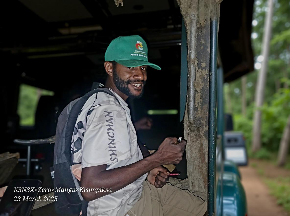 A Papua New Guinean female sitting on a Toyota Land Cruiser, wearing a shirt printed 'KENEX VIBEZ'