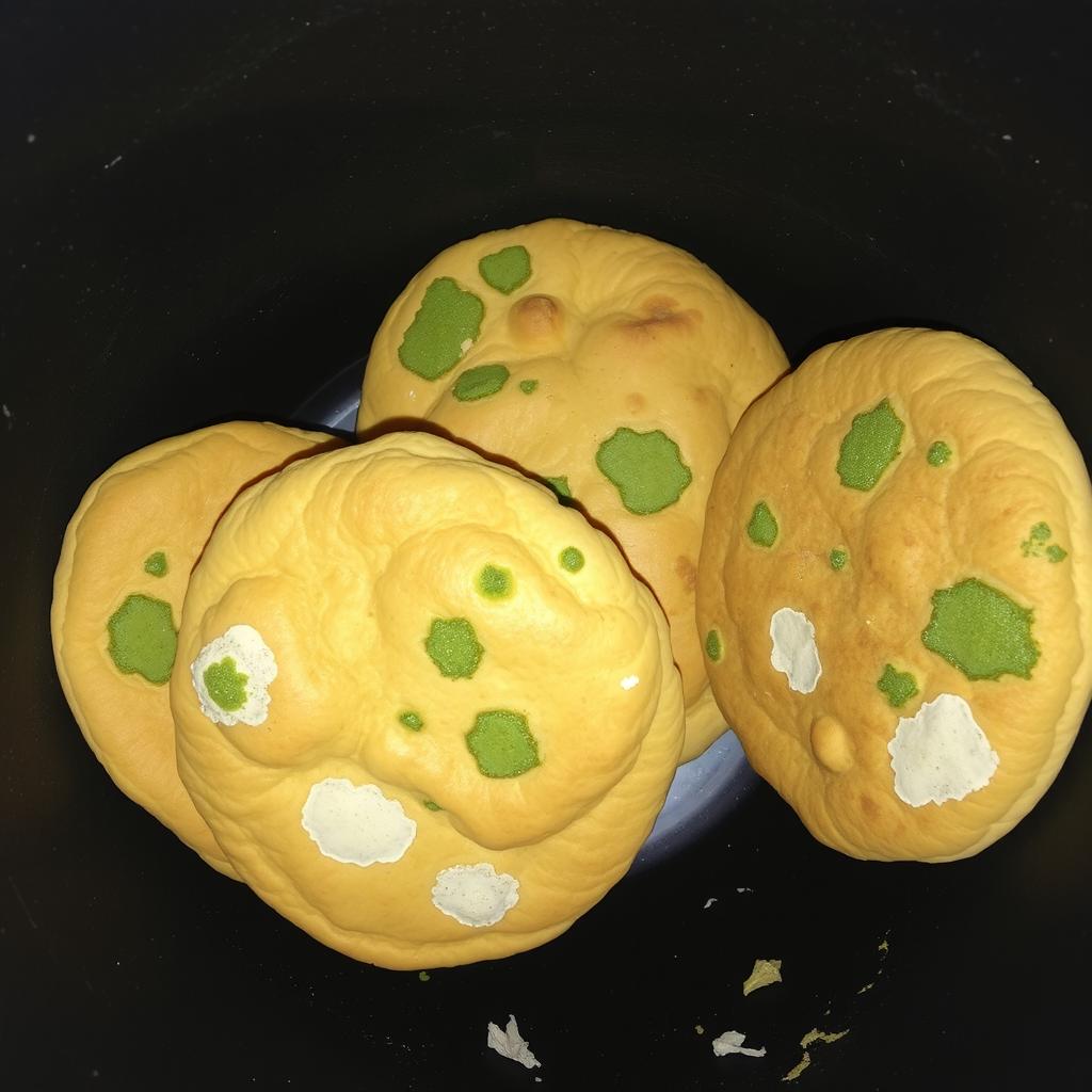 Four Arabic breads, also known as roti, sitting together in a dark, irregularly shaped dustbin