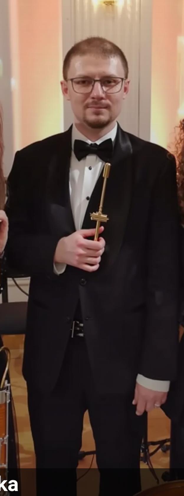 A formal ensemble of musicians in a grand concert hall setting