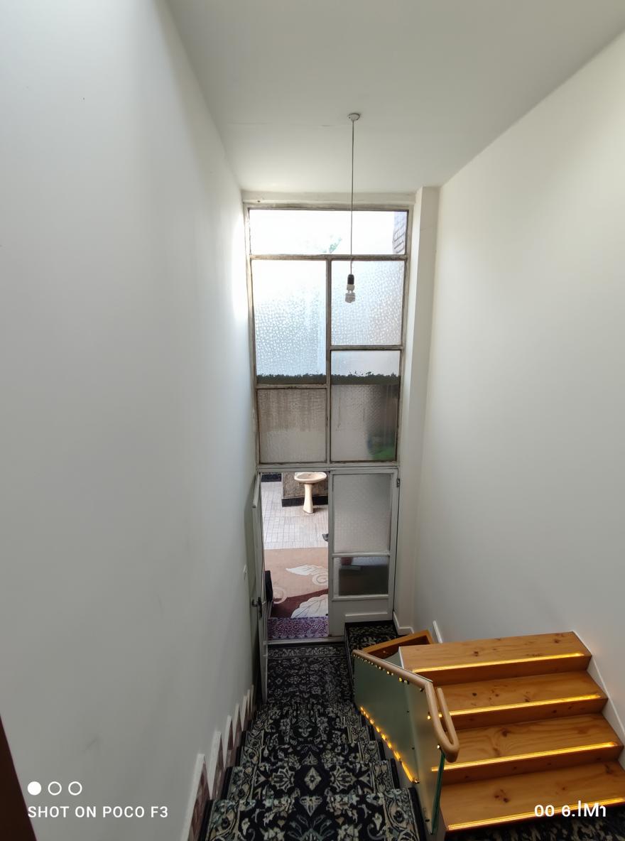 A modern staircase design featuring wooden stairs and sleek glass railings