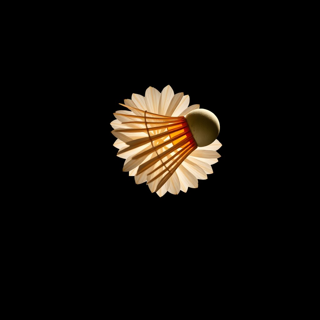 A close-up shot of a shuttlecock gracefully falling through the air, set against a dark, dramatic background
