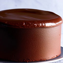 Generate an image of a simple, delicious chocolate cake with a smooth and shiny top