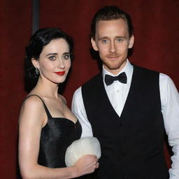 Actor Tom Hiddleston dressed smartly in a white shirt, black vest, and black pants, standing beside a woman with short black hair, pronounced black eye makeup, vibrant red lips, wearing a snow white dress.